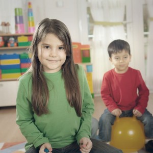 Photo de deux jeunes enfants assis sur des balles rebondissantes ans une crèche